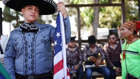 Un participante sostiene una bandera estadounidense en el Día de la Independencia de México en Los Ángeles, a 10 de septiembre de 2023.