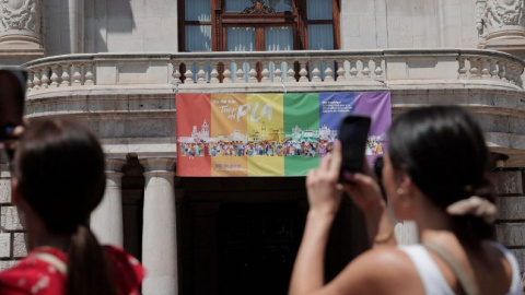 Bandera LGTBI+ colgada en la fachada del Ajuntament de València en 2023. / Manuel Bruque (EFE)