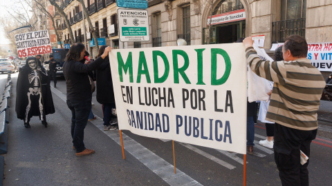 22/09/23-Dos personas sujetan una pancarta durante una cacerolada frente a la sede de la Dirección General de Recursos Humanos del Servicio Madrileño de Salud, a 22 de marzo de 2023, en Madrid.