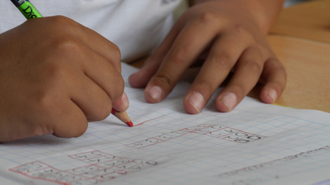 Un niño haciendo deberes en el colegio.