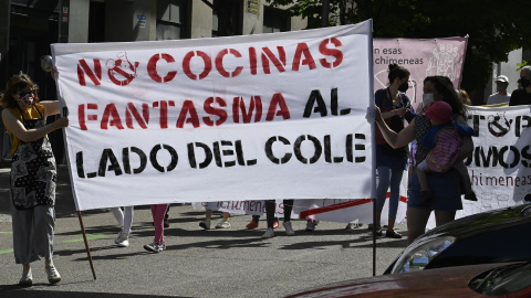 Varias personas participan en la manifestación contra la instalación de 'cocinas fantasma' en zonas residenciales y escolares del distrito madrileño de Arganzuela este sábado.