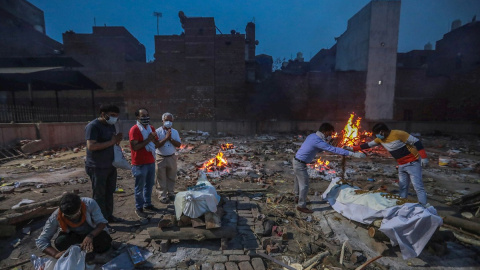 Imagen de archivo de varias personas incinerando a fallecidos por la covid-19, en India. - EFE