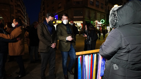 El presidente de la Junta de Andalucía, Juanma Moreno (i) y el candidato del PP a la Presidencia de la Junta de Castilla y León, Alfonso Fernández Mañueco (d), pasean por las calles de Salamanca.