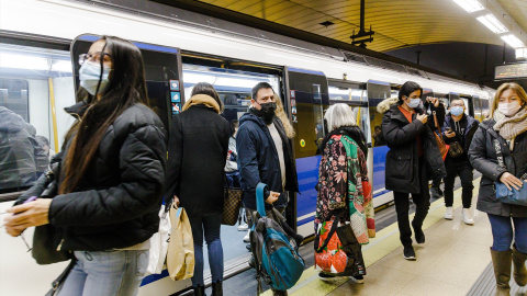 Varias personas bajan y suben de un metro en el andén de la estación de Metro de Callao, a 26 de enero de 2023, en Madrid (España).