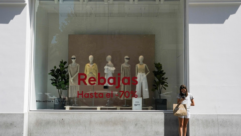 Una joven, junto al escaparate de una tienda de moda en el centro de Madrid. REUTERS/Juan Medina