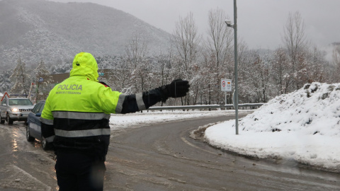 Un mosso fent circular els vehicles a la rotonda d'accés al túnel de Bracons