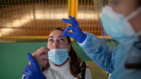 Un trabajador sanitario realiza un test de antígenos a una mujer durante el cribado poblacional celebrado en Ribadavia, en Ourense, este 27 de enero de 2022.