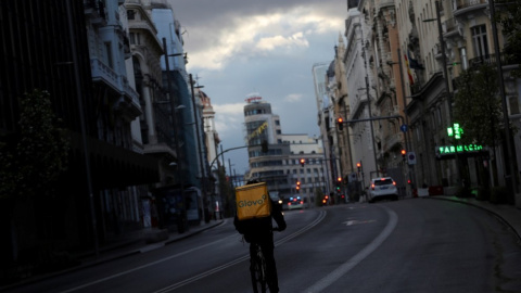 Un repartidor circula en bicicleta por la Gran Vía de Madrid, que permanece prácticamente sin coches debido a la crisis del coronavirus. Reuters/Susana Vera