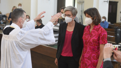 El vicario parroquial Wolfgang Rothe bendice a una pareja de lesbianas Christine Walter y Almut Muenster durante un servicio religioso en la iglesia de Saint Benedikt en Munich el 9 de mayo de 2021.