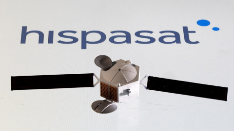 Una maqueta de un satélite de comunicaciones junto al logo del operador español Hispasat. REUTERS/Dado Ruvic/Illustration