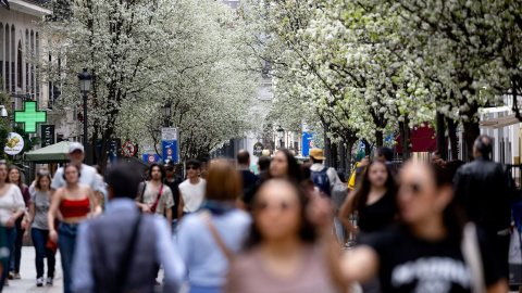 Varias personas pasean junto a árboles en flor durante el primer día de primavera, a 20 de marzo de 2024, en Madrid.