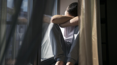 Retrato de un hombre con cortinas y sombras desde la ventana