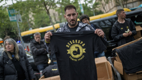 Una persona reparte camisetas durante una manifestación convocada por la empresa Desokupa a favor de los desalojamientos forzosos de El Kubo y La Ruïna en la Plaza Bonanova.