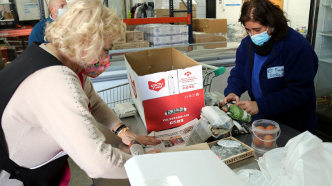 Voluntàries de la Plataforma d'Aliments de Manresa preparen lots per repartir.