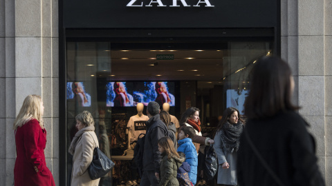 Varios transeúntes pasan por delante de una tienda de Zara anunciando descuentos en el primer día de las rebajas de invierno en Barcelona. el 7 de enero de 2017.