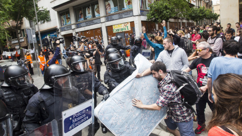 Agentes antidisturbios de los Mossos rodean los accesos del 'Banc Expropiat' de Barcelona tras dispersar a empujones al centenar de personas que se habían concentrado a las puertas de la finca, en apoyo a los okupas. EFE/Quique García