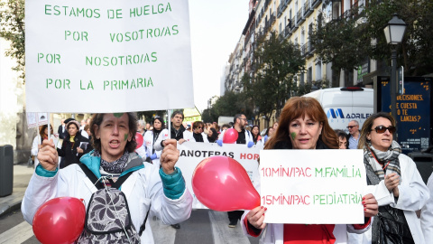 Dos mujeres con bata blanca y pancartas durante una concentración de médicos y pediatras de Atención Primaria en huelga, desde la sede de la Dirección General de Recursos Humanos del Servicio Madrileños de Salud, a 22 de febrero de 2023, en Madrid (E