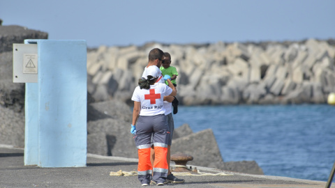 Dos voluntarios de Cruz Roja atienden a uno de los menores llegados al puertos de la Restinga en un cayuco el pasado fin de semana.