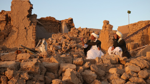 Residentes afganos sentados en una casa dañada tras el terremoto en la aldea de Sarbuland en Zendeh Jan, distrito de la provincia de Herat, el 7 de octubre de 2023.