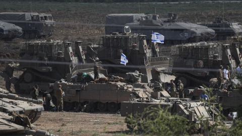 Tropas israelíes y vehículos militares, entre ellos tanques, se reúnen en un lugar no revelado a lo largo de la frontera con Gaza.