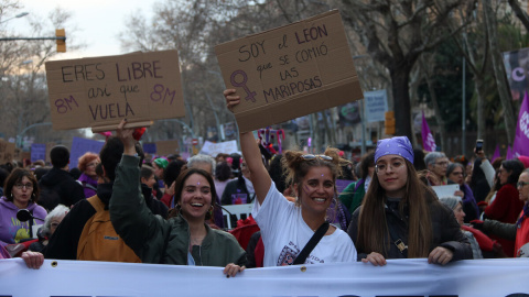 Tres manifestants mostren pancartes a la marxa feminista del 8-M a Barcelona.