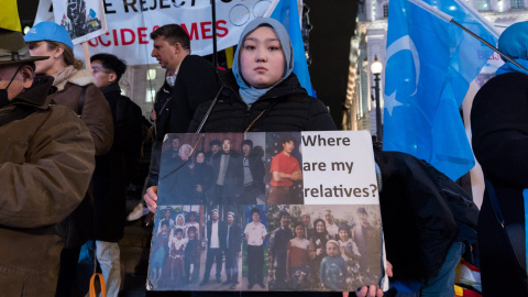 Una mujer uigur sostiene un cartel con fotografías de sus familiares, en una protesta en Piccadilly Circus, a 3 de febrero de 2022 en Londres, Inglaterra.