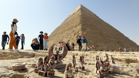 Pequeñas figuritas "souvenirs" descansan en el suelo junto a las pirámides de Guiza ante los ojos de decenas de turistas este 2 de marzo de 2023.