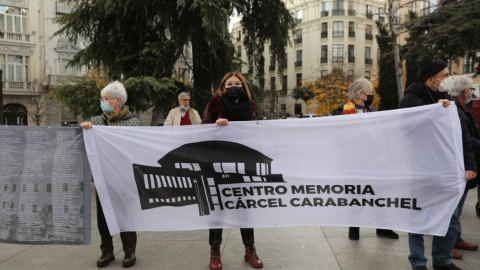 Varias personas sostienen una pancarta que reclama la construcción de un centro para la memoria histórica en la antigua cárcel de Carabanchel, en una manifestación por los derechos de las víctimas del franquismo frente al Congreso de los Diputados, a