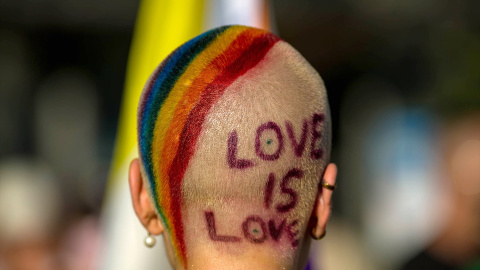 Imagen de archivo de una persona con los colores de la bandera LGBTI en la cabeza y el mensaje "Love is love".