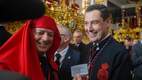 El presidente de la Junta de Andalucía, Juanma Moreno,  antes de empezar la estación de penitencia del Santísimo Cristo de la Exaltación a 5 de abril de 2023 en Málaga.