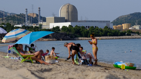 La central nuclear Vandellós II se ve al fondo mientras la se baña en la playa de la Almadraba en Hospitalet del Infante, en Tarragona.