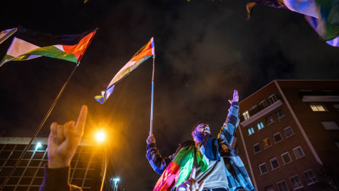 Manifestante grita sosteniendo una bandera palestina, durante una concentración de emergencia por los últimos acontecimientos en Gaza, frente a la embajada Israelí, a 18 de octubre de 2023