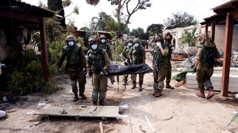 Soldados israelíes llevan el cuerpo de una de las víctimas del ataque de milicianos de Hamás al Kibbutz Kfar Aza, en el sur de Israel. REUTERS/Ronen Zvulun