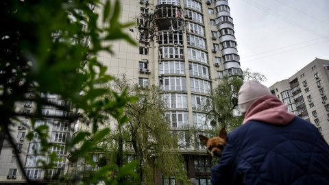 Una mujer mira un bloque de apartamentos dañado por los escombros de la explosión de un dron ruso en Kiev, Ucrania, el 8 de mayo de 2023.