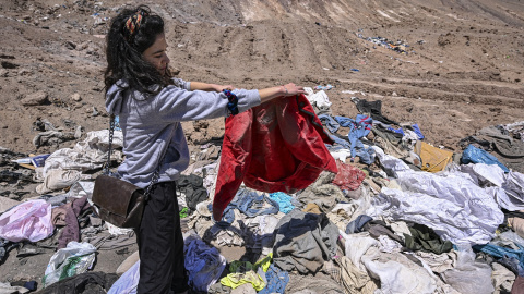 Una mujer examina las prendas abandonadas en el desierto de Atacama, en Chile, a 15 de noviembre de 2022.