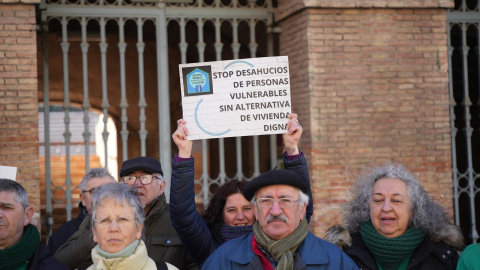 Una mujer levanta una pancarta de 'Stop desahucios' durante una concentración de la Plataforma de Afectados por la Hipoteca (PAH) .