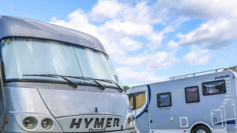 Autocaravanas para jornaleros de la nieve y viajeros, en el parking de la localidad oscense de Castejón de Sos