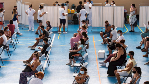 Multitud de jóvenes aguardan sentados tras recibir la vacuna contra el coronavirus en Espartinas, Sevilla.