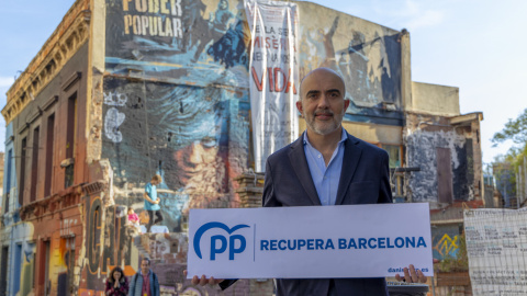 El candidat del PPC a l'Ajuntament de Barcelona, Daniel Sirera, amb el seu lema de campanya front a la icònica casa ocupada de Sant, Can Vies.