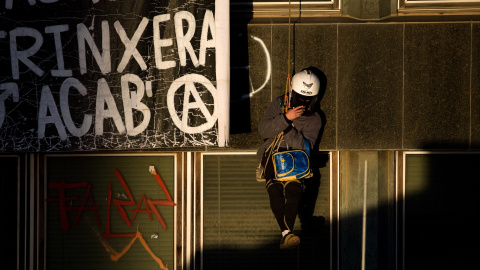 Un okupa colgado de la pared de los edificios de la Ruïna y el Kubo, en la plaza Bonanova, a 30 de noviembre de 2023.