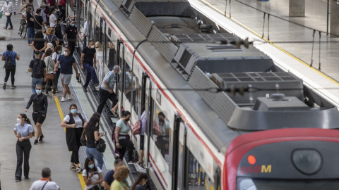 Viajeros suben a un tren de cercanías en la estación de tren de Santa Justa.