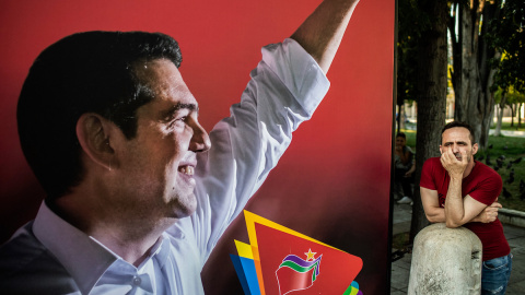 Un partidario del partido Syriza junto a un cartel electoral del primer ministro griego Alexis Tsipras, el 7 de julio de 2019, en Atenas.