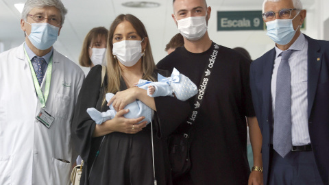 La pareja formada por Tamara y Jesús posan con el conseller de Salud, Manel Balcells (d), el jefe del servicio de Ginecología del Hospital Clínic, Francisco Carmona (i), y su hijo, el pequeño Jesús.