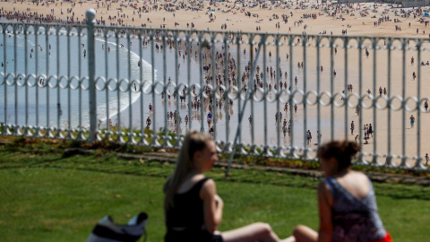 Dos jóvenes disfrutan junto a la playa de La Concha de San Sebastián.