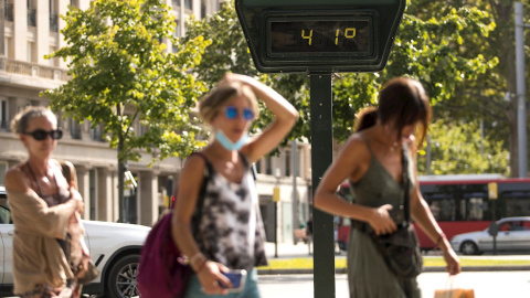 Varias personas pasean por el centro de Zaragoza en plena ola de calor marcando los termómetros hasta 41º.