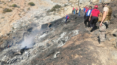 Miembros de los equipos de búsqueda y rescate inspeccionan el avión anfibio ruso Be-200 estrellado.