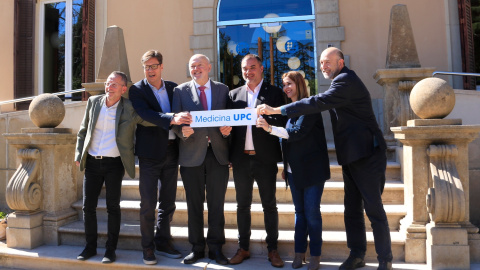 El rector de la UPC, Daniel Crespo; l'alcalde de Terrassa, Jordi Ballart i representants de les dues institucions aguanten un cartell que anuncia el projecte per crear nous estudis de Medicina, davant el rectorat de la universitat