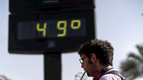 Un hombre toma una bebida junto a un termómetro de Córdoba en otra jornada marcada por la ola de calor en la que hay previsiones de que las temperaturas alcancen los 47 grados en el Valle del Guadalquivir.