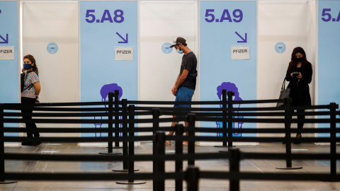 Varias personas esperan su turno para recibir una dosis de la vacuna contra la covid en Barcelona.