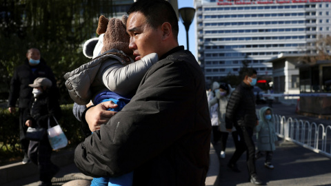 Un hombre con su hijo a las puertas de un hospital en Pekín, China, este 24 de noviembre de 2023.